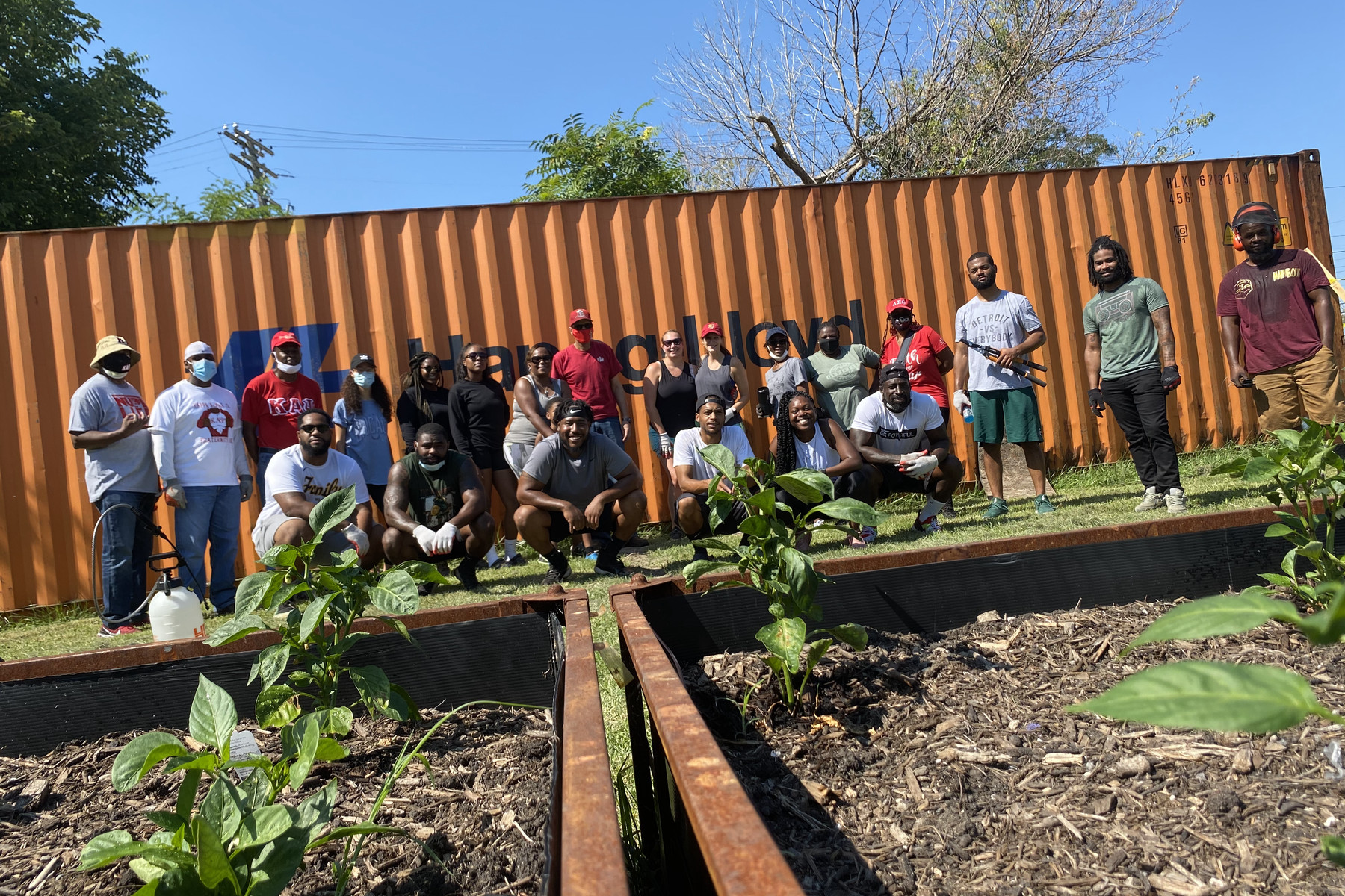 Peace Tree Parks volunteers working along rows of raised beds at a Detroit community garden