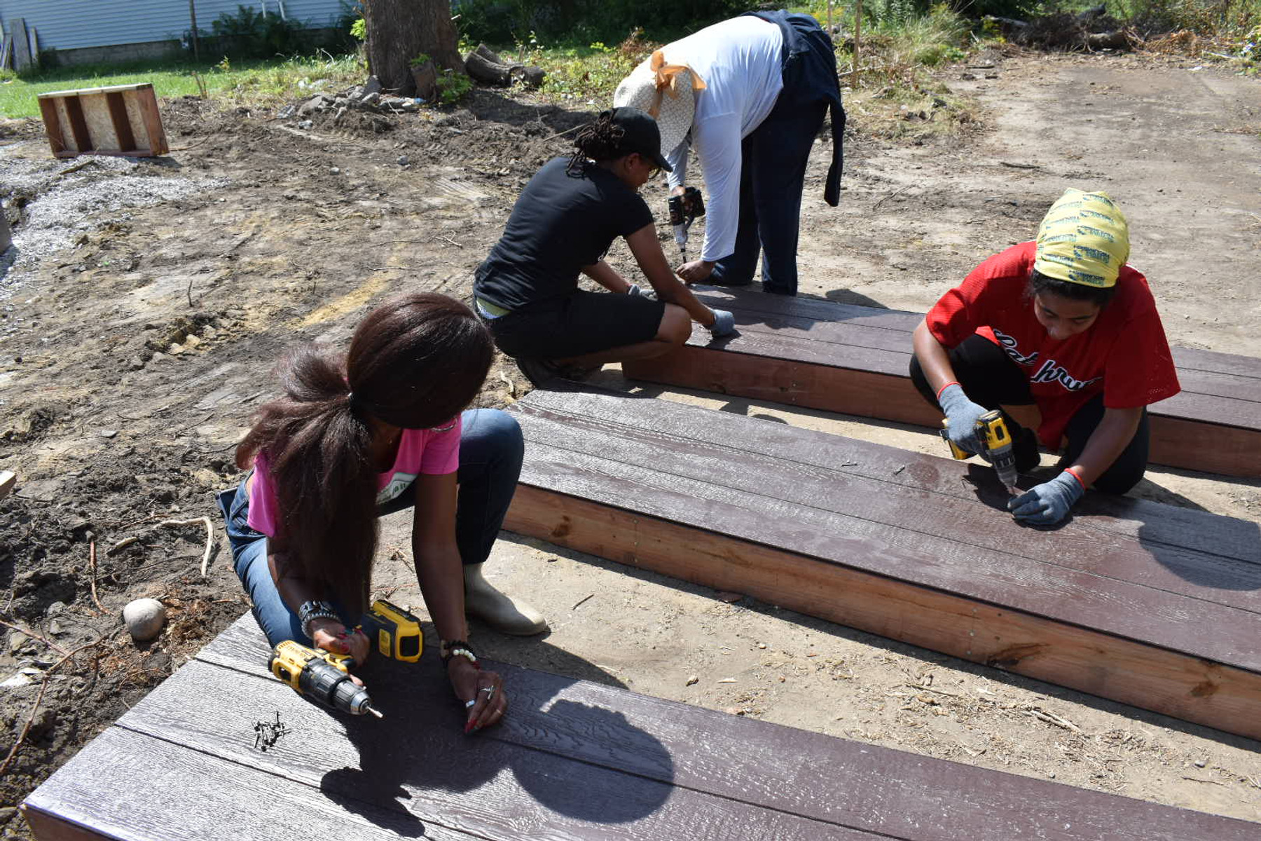 Volunteers assembling a wooden raised garden bed on a Detroit lot